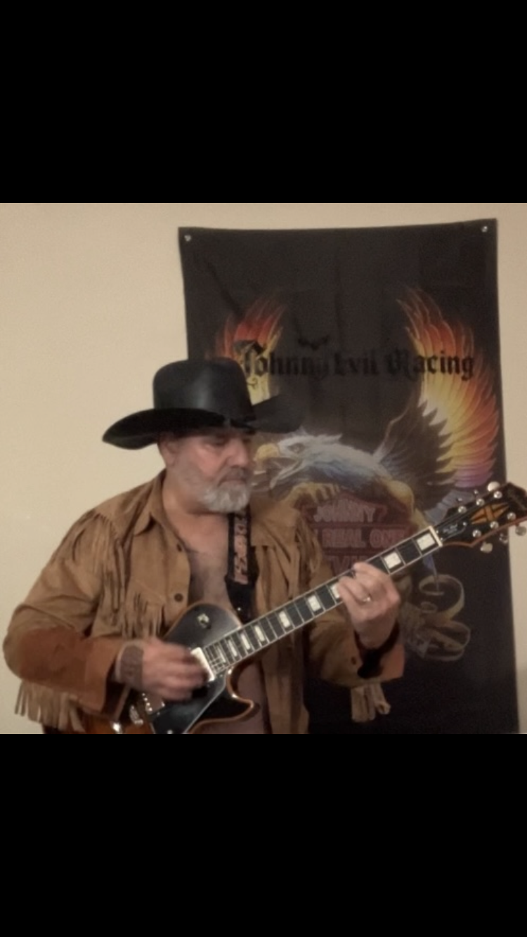 Johnny Evil Racing guitarist with band banner